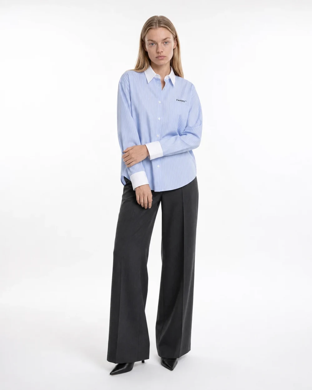 Eva wearing the blue Fantasy pinstripe shirt in a clean white studio