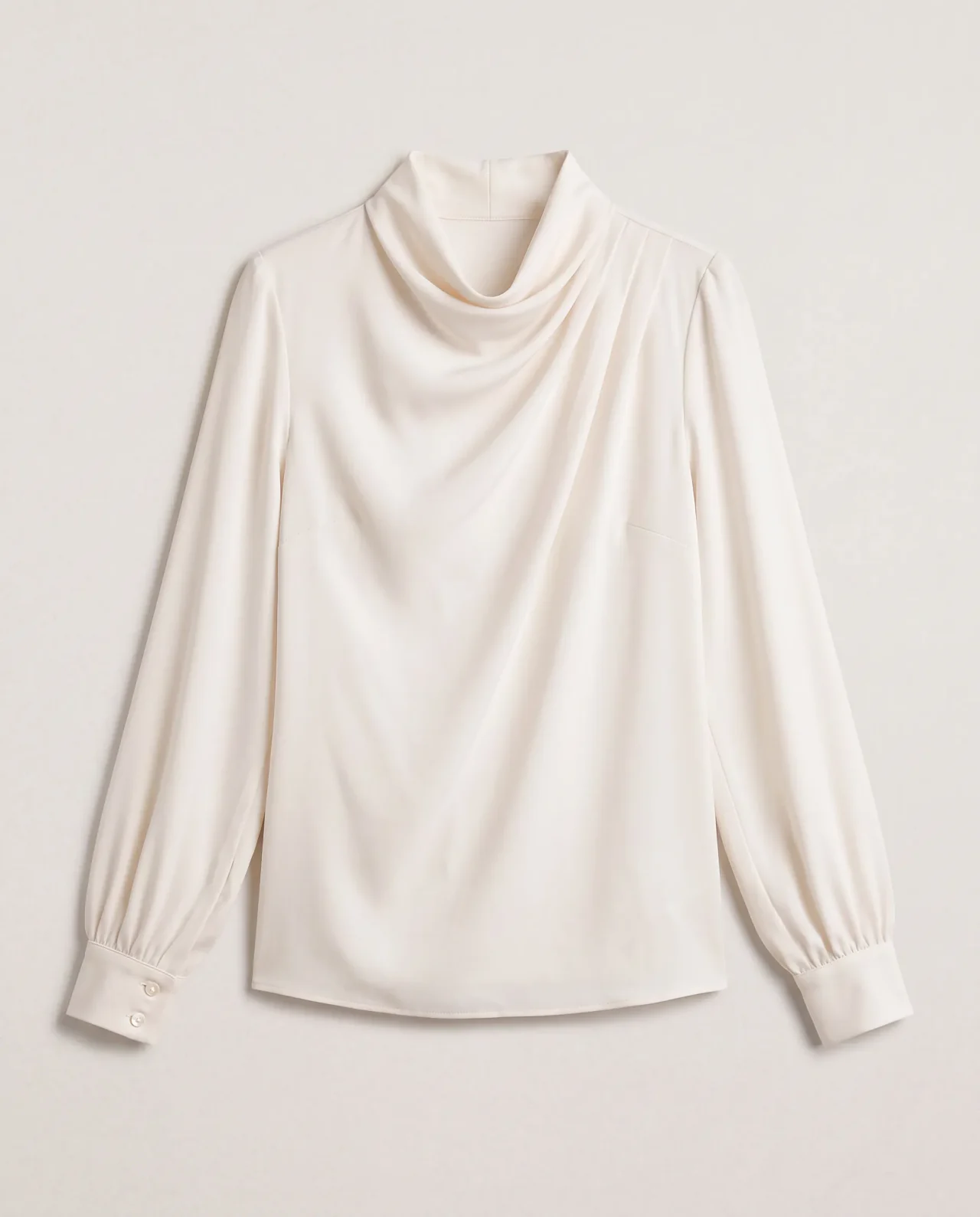 Flat lay of an ivory draped blouse with a cowl neckline